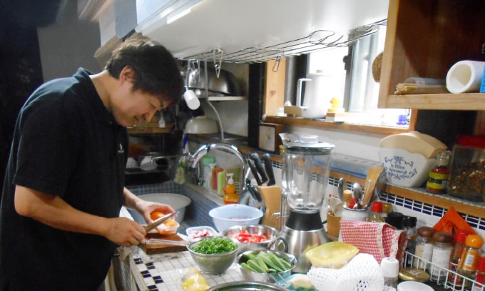 台所で料理をする青山
